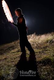 backlit fire performer with fire sword in Errington